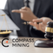 Logo de Compass Mining junto a martillo de ley.
