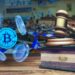 moneda de bitcoin entre monedas digitales junto a libro de leyes con bandera de El Salvador y martillo de juez, con asamble legislativa en el fondo