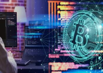 programador trabajando código en computadora con logo de bitcoin digital al lado