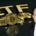 Nate Geraci junto a monedas de bitcoin apiladas sobre mesa con ETF en el fondo
