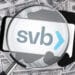 Logo Silicon Valley Bank detrás de una lupa con dolares de fondo.