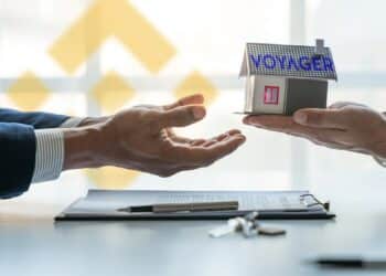 empresarios intercambiando bienes de voyager con logo de Binance en el fondo y contrato sobre mesa