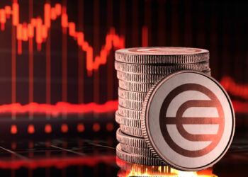 moneda de worldcoin apoyada en monedas apiladas con grafico de precio en rojo al fondo
