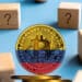 Bitcoin y bloques de madera con signo de interrogación.