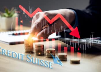 Logo de Credit Suisse junto a monedas y grafico bajista.