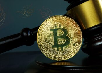 moneda de bitcoin apoyada en martillo de juez con sombreros de bruja en el fondo