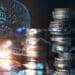 monedas apiladas junto a inteligencia artificial