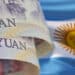 billetes de yuanes con bandera de Argentina en el fondo