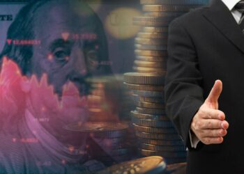 hombre ofrece mano con monedas apiladas y billete de dolar con grafico bajista en rojo en el fondo