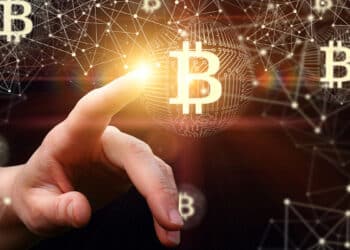 mano seleccionando logo de bitcoin en red