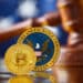 moneda de bitcoin sobre escritorio con logo de la SEC, martillo de juez y bandera de los Estados Unidos en el fondo