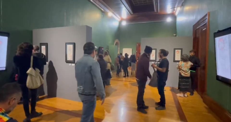 personas paseando y observando la exposición de arte NFT llevada a cabo en la Antigua Academia de San Carlos de la Universidad Nacional Autónoma de México (UNAM)
