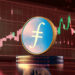 moneda de filecoin sobre monedas apiladas con grafico de precio cayendo en el fondo