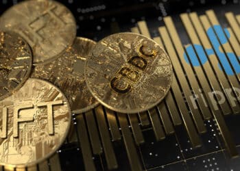 monedas de NFT y CBDC sobre superficie metalica con logo de Ripple grabado