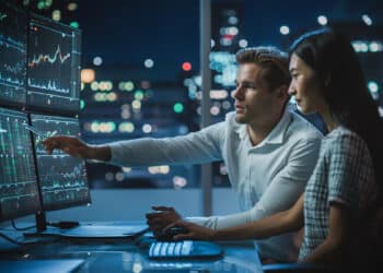 traders viendo graficos de precio en pantallas