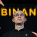 manos señalando a Changpeng Zhao, CEO de Binance con logo de la empresa detrás