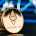 moneda de ethereum apoyada en monedas apiladas con grafico en el fondo