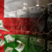 Mineros de bitcoin, bandera de Omán y dólares.