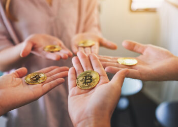 manos sosteniendo monedas de bitcoin