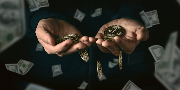 manos sosteniendo monedas de bitcoin con billetes de dolares cayendo alrededor