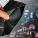 mano sosteniendo wallet vacia con hacker acumulando monedas de monero en el fondo