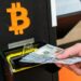 Persona introduciendo billetes en un cajero Bitcoin