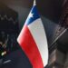 Pantalla con gráficos financieros, fallada de banco y bandera de Chile
