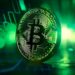Moneda de Bitcoin entre luces verdes