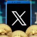 logo de red social X en un teléfono móvil rodeado de monedas de bitcoin