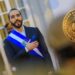 El presidente de El salvador, Nayib Bukele, y un bitcoin a su derecha.