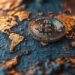 Mapa mundi con moneda de bitcoin en el centro