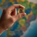 Una mano sosteniendo un bitcoin y al fondo aparece un mapa de Brasil.