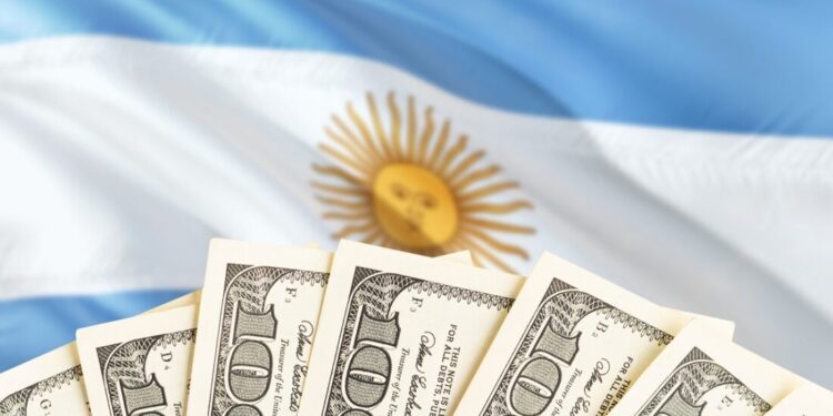 Dólares estadounidenses delante de la bandera de Argentina