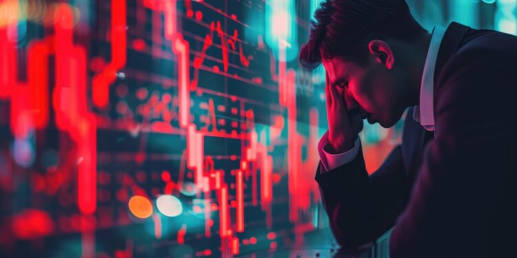 Inversionista con rostro preocupado, delante de un gráfico en rojo.