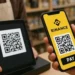Usuario utiliza su smartphone para pagar con Binance via codigo QR.