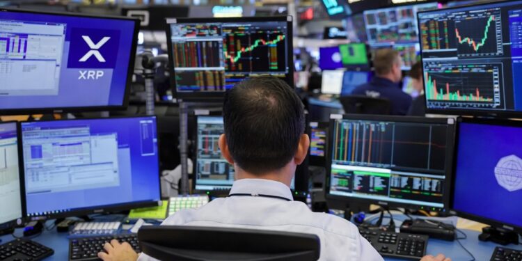 Un trader visto desde atrás, sentado frente a una estación de trabajo con múltiples monitores en el piso de operaciones de la Chicago Mercantile Exchange.