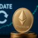 moneda física dorada de Ethereum y en el fondo una pantalla azul con la palabra “UPDATE” y un gráfico financiero que muestra una tendencia alza.