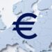 Símbolo del Euro en color azul oscuro frente a un mapa de europa en color azul claro.