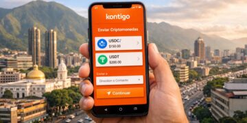 Mano sosteniendo un smartphone con la app Kontigo con la ciudad de Caracas y el cerro Ávila de fondo.