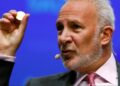 Imagen en primer plano de Peter Schiff con una moneda de oro en la mano
