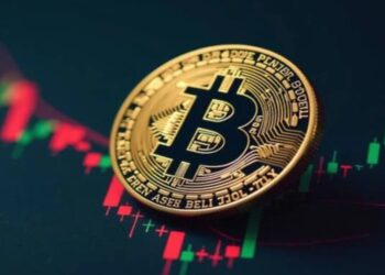 Una moneda física de bitcoin sobre un gráfico de precios.