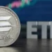 Una moneda física de solana junto a las letras ETF.