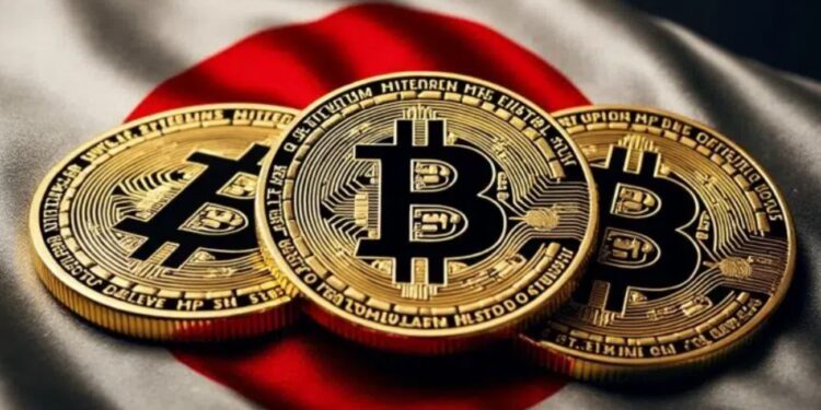 Tres monedas físicas de bitcoin doradas sobre una bandera de Japón.