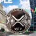 Moneda física de XRP en primer plano e imágenes típicas de Wall Street en el fondo.
